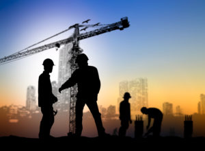 silhouette engineer looking Loaders and trucks in a building site over Blurred construction worker on construction site